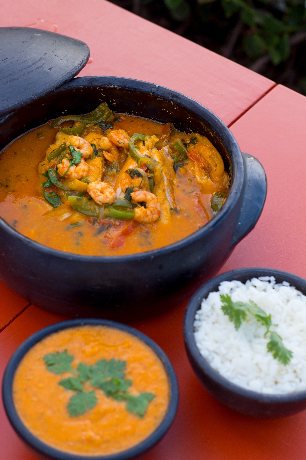 Moqueca de camarão servida na panela de barro, com pirão e arroz branco