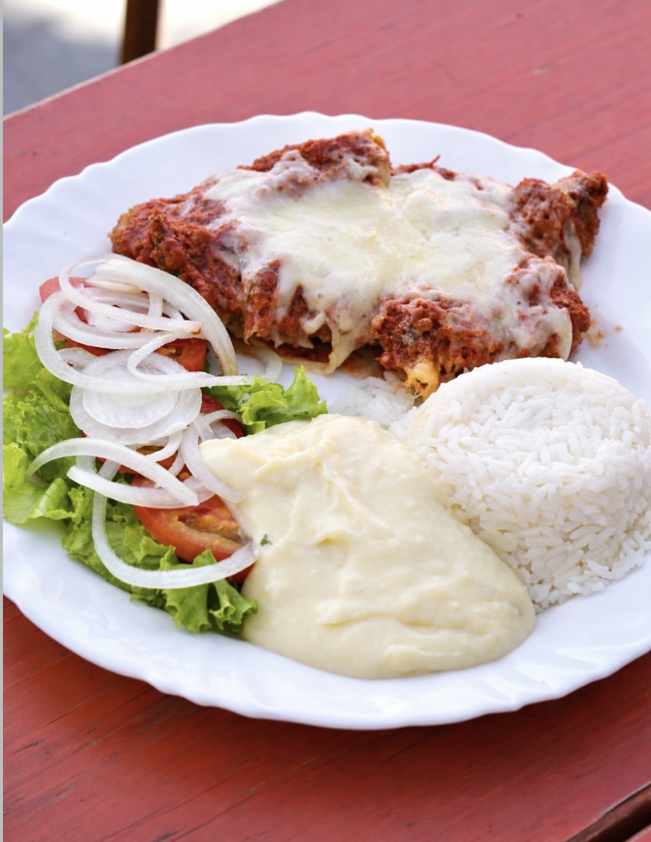 Filé à parmegiana gratinado com queijo, arroz e batata frita
