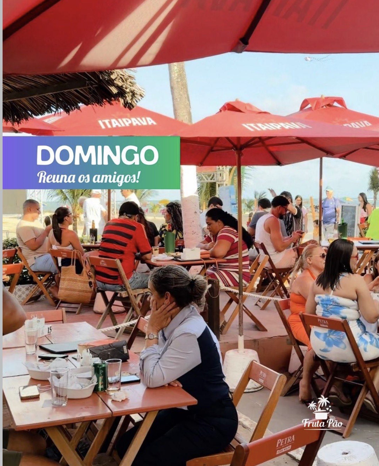 Salão cheio no domingo, com guarda-sóis vermelhos e clientes à mesa